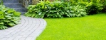 Manicured lawn and stone coloured block paved path